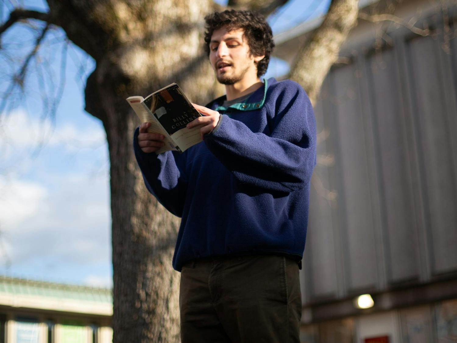 Ben Goldman, a former UNC student, reads poetry in the Pit on Monday, Jan. 18, 2021. Goldman is pictured here reading works by Billy Collins.