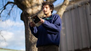 Ben Goldman, a former UNC student, reads poetry in the Pit on Monday, Jan. 18, 2021. Goldman is pictured here reading works by Billy Collins.