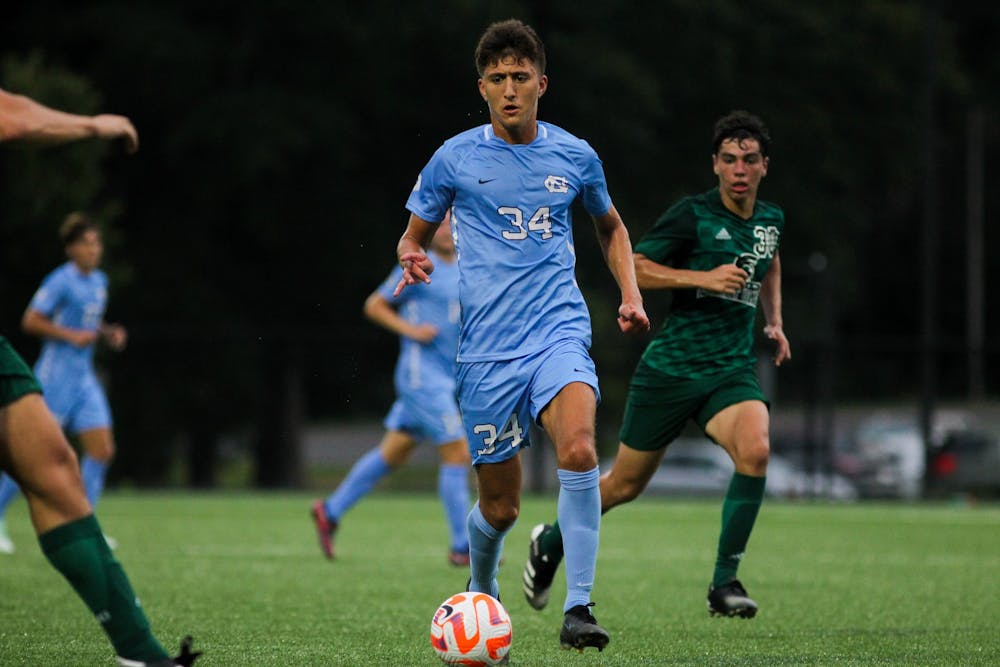 <p>Junior midfielder Ahmad Al-Qaq (34) dribbles the ball towards the Mount Olive goal. UNC tied 1-1 against Mount Olive on Monday, Aug. 15, 2022</p>