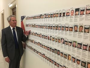 U.S. Rep. Walter Jones, R-N.C., stands in front of a wall of photos of fallen soldiers outside his office. Jones sends condolence letters to the families of soldiers who have died in the Middle East because of his decision to vote in favor of the Iraq war in 2002. Photo courtesy of Allison Tucker.