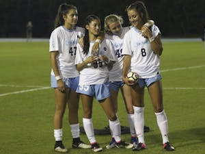 UNC midfielder Abby Elinsky (8) is embraced by her teammates Alex Kimball (47), Jenny Chiu (95) and Cannon Clough (49) before the start of Thursday night's game against Florida State. Elinsky lost her older brother, Nick, on October 2nd.