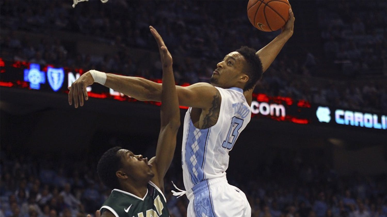 Forward J.P. Tokoto (13) makes the dunk during the win against UAB.