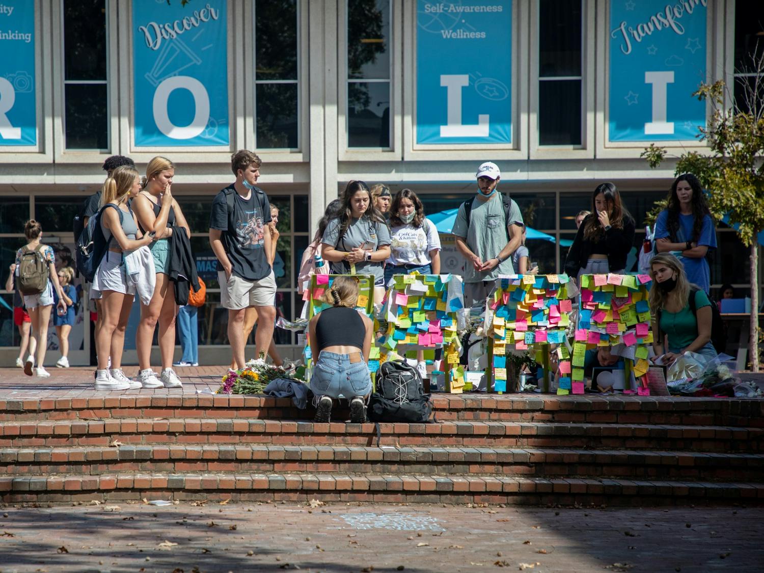 Content warning: This text contains mention of suicide.
Students add notes and flowers to the memorial in the Pit on Oct. 14, 2021. The memorial commemorates students who died by suicide during the fall 2021 semester.
