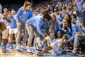 The UNC women's basketball team celebrates redshirt senior guard Madinah Muhammed (3) after she fell for a shot. The Tar Heels beat the Tigers 86-72 on Sunday, Feb. 2, 2020 in Carmichael Arena.