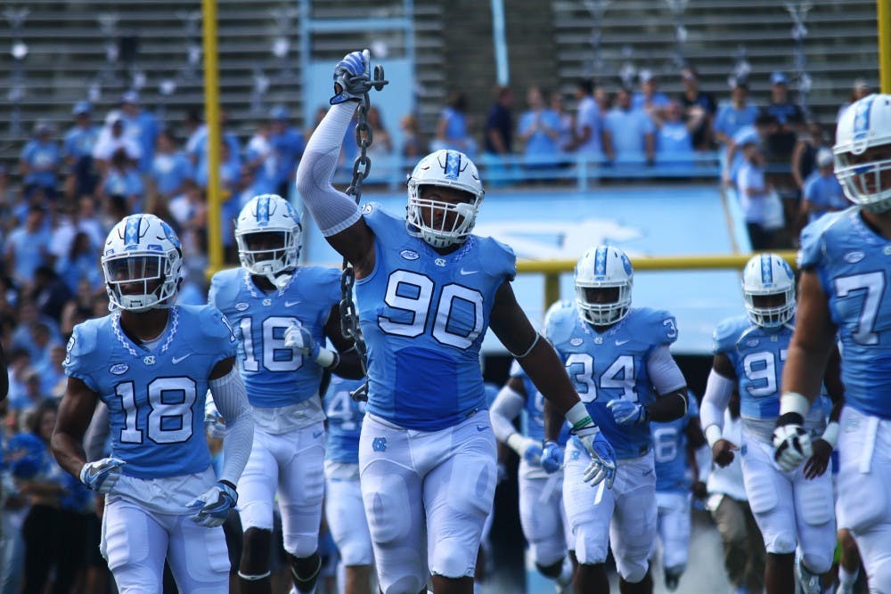 Nazair Jones (90) holds up a chain as the team walks out of the tunnel at the beginning of the game against Pitt. 