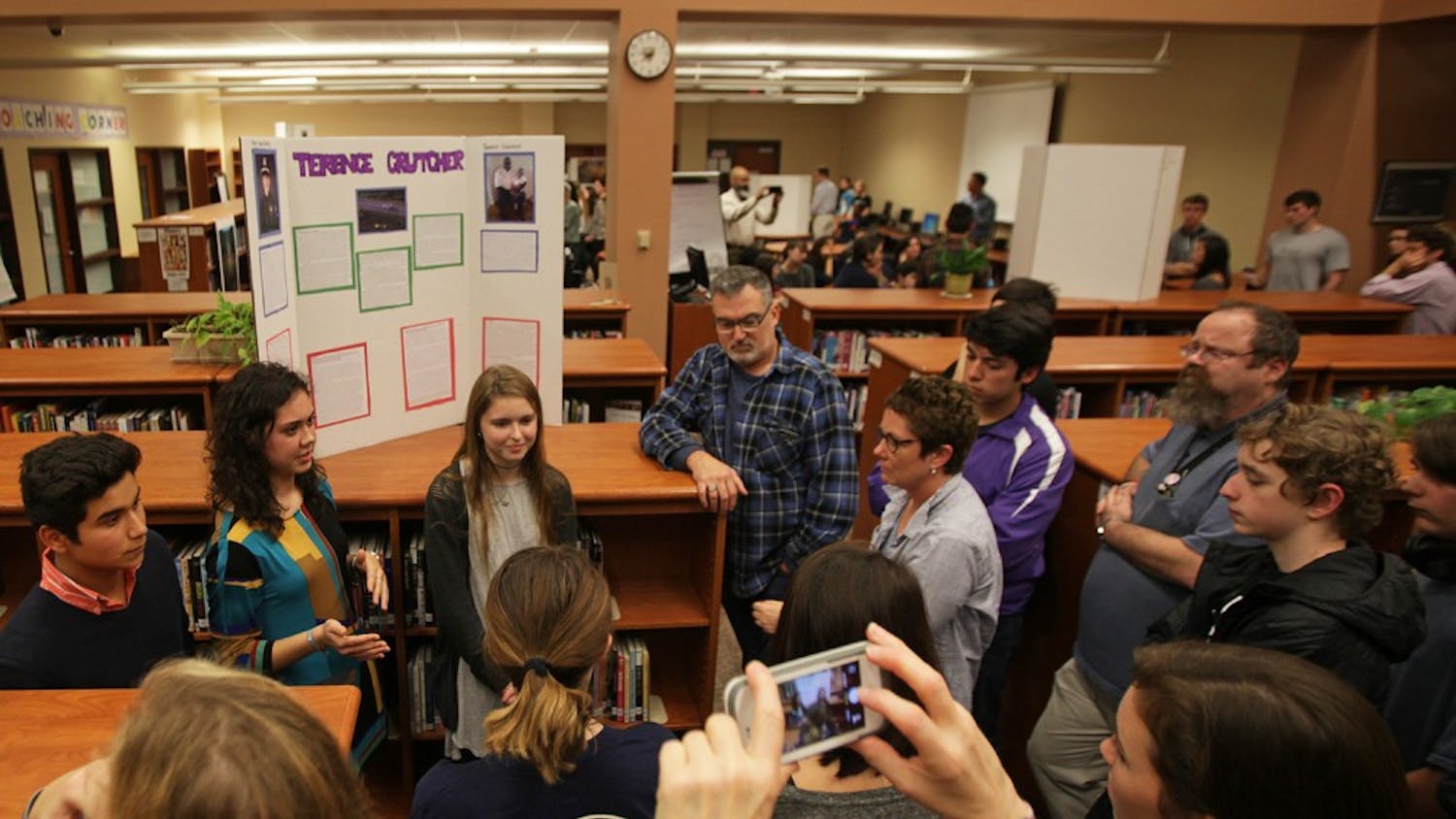 Carrboro High School students (from left) Amado Ruiz-Perez, Sophie Therber and Lily Ervin, give a presentation on Terence Crutcher, one of many victims of recent police shootings Tuesday evening.  