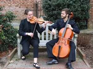 Emma Schubart (left), a sophomore music performance and political science major, and Daniel Malawsky (right), a junior biostatistics and mathematics major, play in front of Patterson Hall on Sunday, Feb. 3, 2019. Emma and Daniel are both part of the student orchestra of the opera at UNC. 