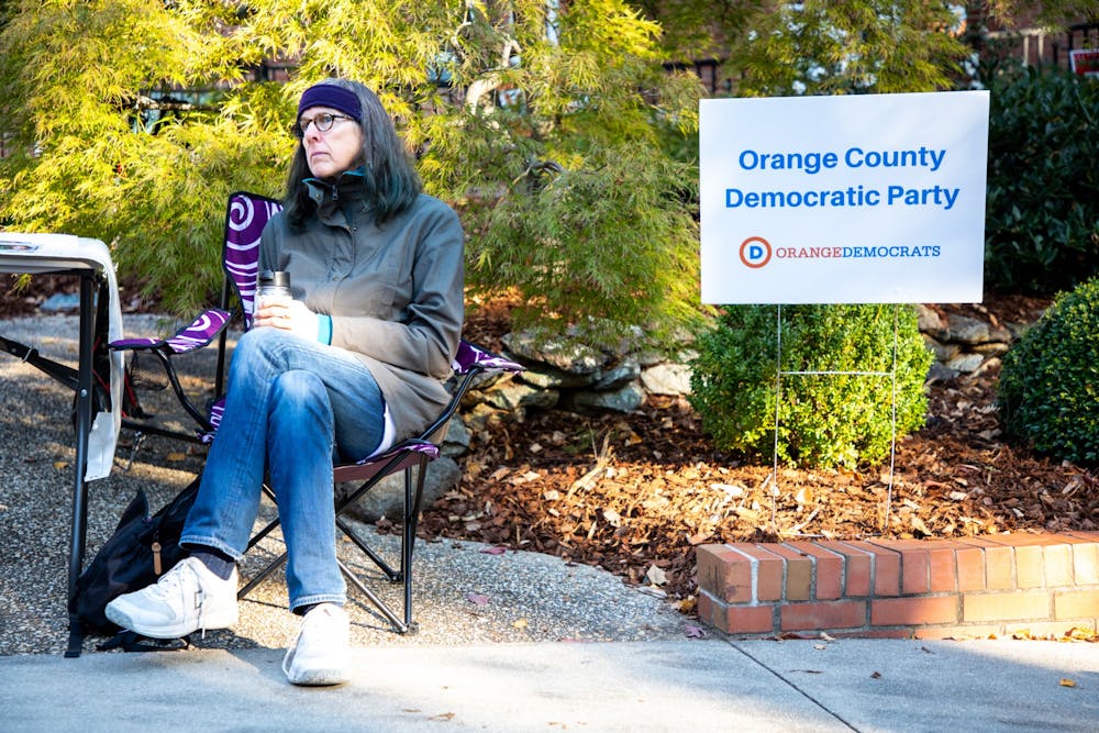 Melissa McCullough, co-chair of the precinct for the Orange County Democratic Party, waits to speak with voters outside Holy Trinity Lutheran Church on Election Day, Nov. 2, 2021.
