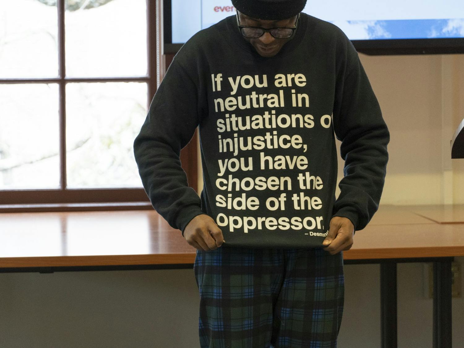 A UNC Hussman Masters student shows off his sweatshirt at the Martin Luther King Jr. Day walk-out/sit-out on Tuesday, Jan. 17, 2023. 