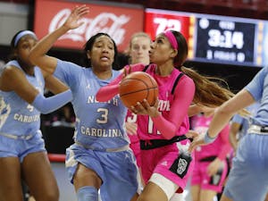 N.C. State's Jakia Brown-Turner (11) drives to the basket past North Carolina's Kennedy Todd-Williams (3) during the second half of N.C. State’s 82-63 victory over UNC in the annual Play4Kay game at Reynolds Coliseum in Raleigh, N.C., Sunday, February 21, 2021. Photo courtesy of Ethan Hyman.
