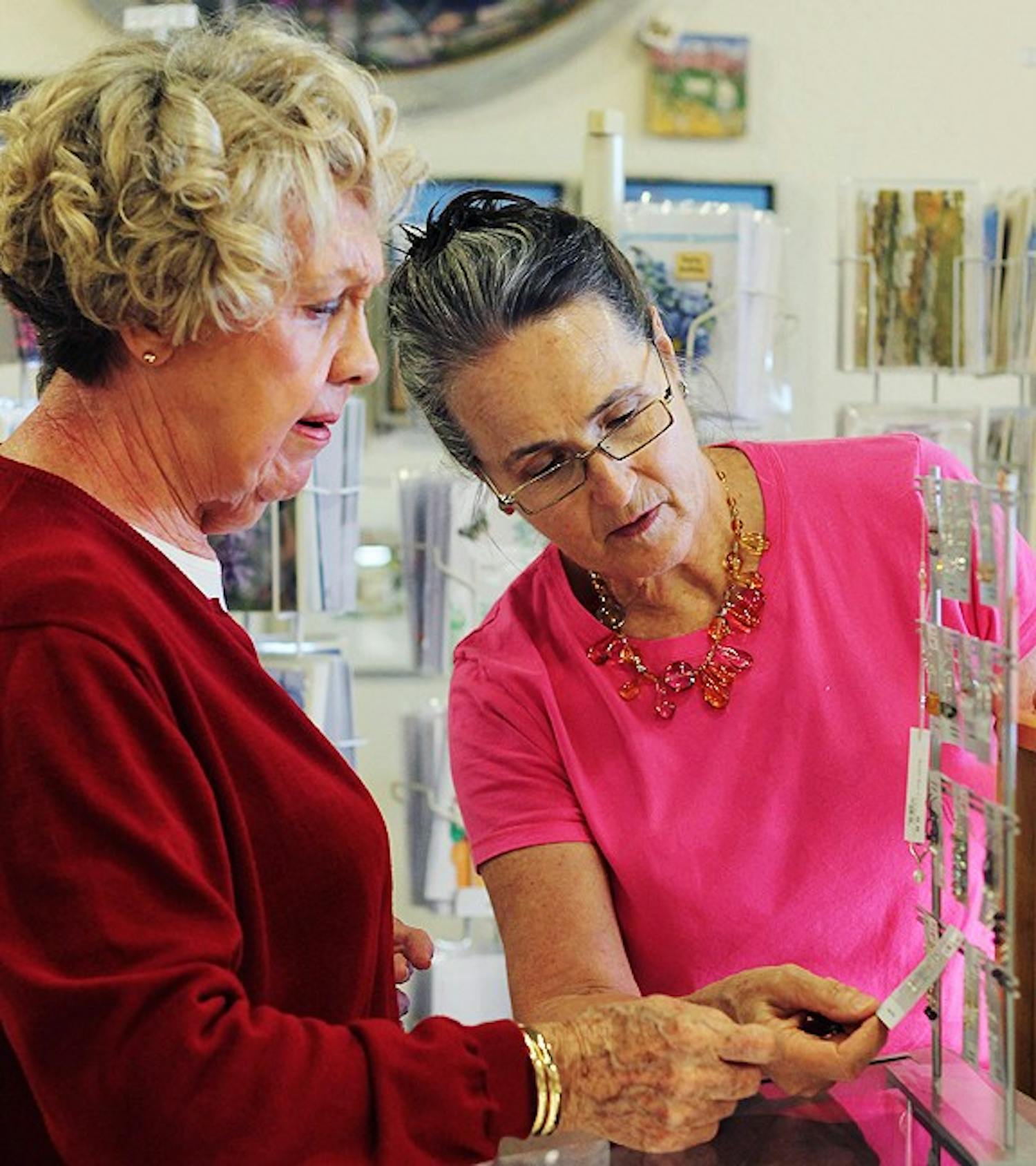 Loyal Womancraft Gifts patron, Edna Webster, (left) and Karen Graves, Display Chair, (right) discuss a jewelry purchase.  Webster loves the atmosphere of the store, the ladies are very helpful and the prices are reasonable.  Graves has been working at Womancraft Gifts since 1976 and loves the work environment said it was great way to learn and share with other artists.                                                                                                                                                                                                  