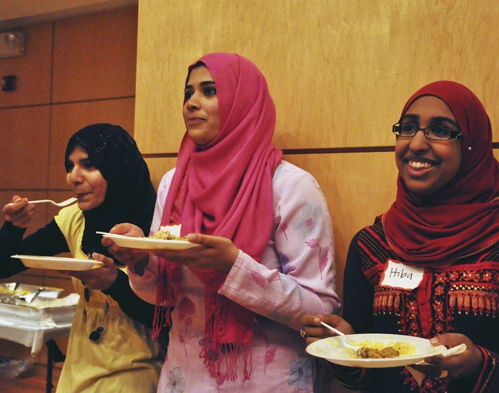 Umber Siddiqui (left), Ruhina Shemna (center) and Hiba Chohan (right) enjoy a Pakistani meal of chicken, rice, potatoes, peas and salad provided by Olive Green in Raleigh. Students met in the Great Hall to help break the fast at sundown, where special speakers applauded the students for their hard work and donation to the flood victims in Pakistan.