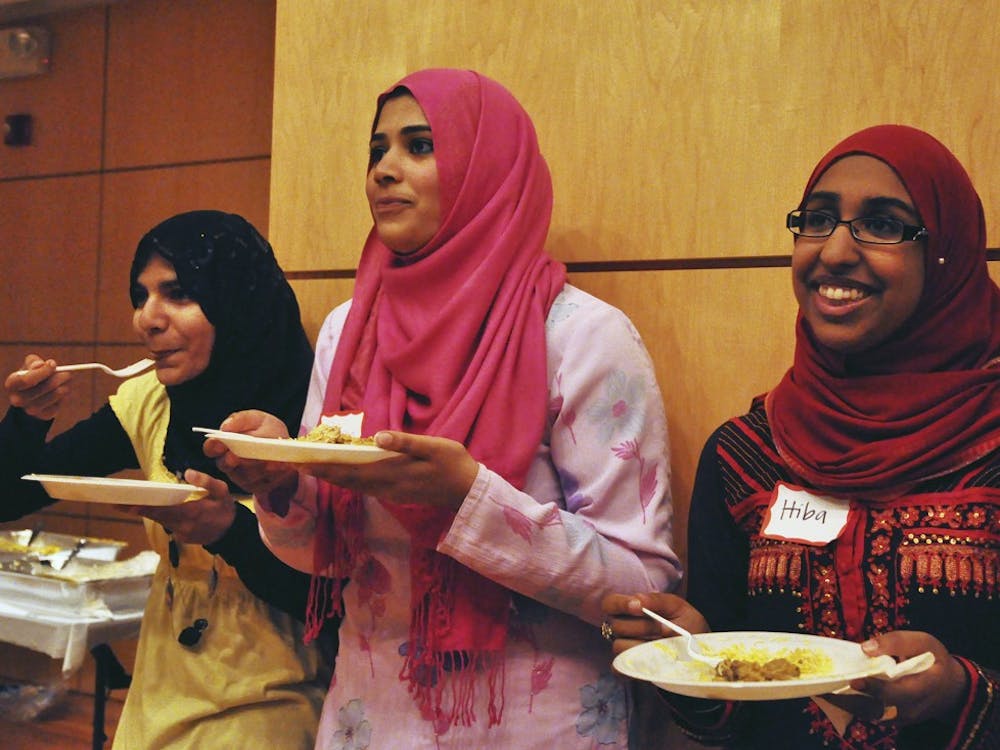 Umber Siddiqui (left), Ruhina Shemna (center) and Hiba Chohan (right) enjoy a Pakistani meal of chicken, rice, potatoes, peas and salad provided by Olive Green in Raleigh. Students met in the Great Hall to help break the fast at sundown, where special speakers applauded the students for their hard work and donation to the flood victims in Pakistan.