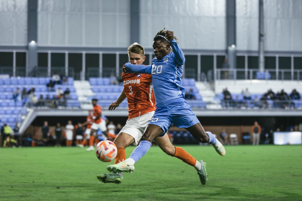 UNC junior Ernest Bawa (20) keeps the ball away from a Clemson player in the men's soccer game against Clemson on Monday, Oct. 3, 2022, at Dorrance Field. Clemson topped UNC 1-0.