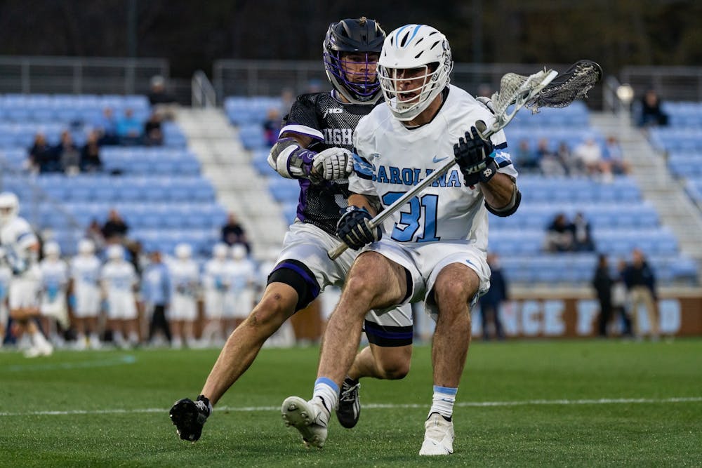 <p>UNC graduate midfielder Connor Maher (31) runs with the ball during the men's lacrosse game against High Point on Wednesday, March 22, 2023, at Dorrance Field. UNC beat High Point 16-9.</p>
