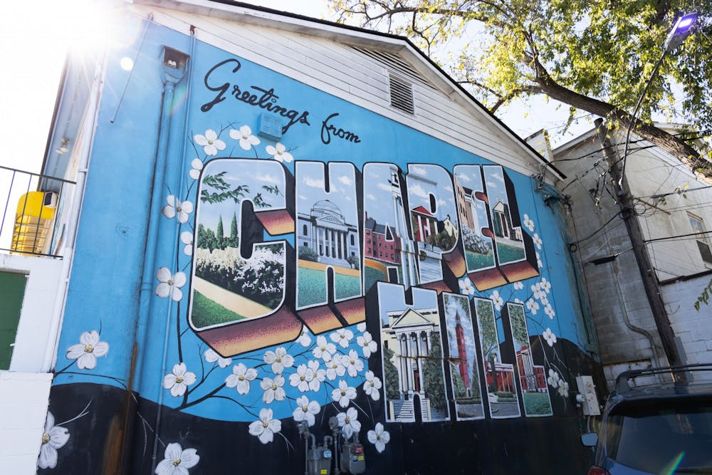 <p>The "Greetings from Chapel Hill" postcard mural located behind He's Not Here, pictured on Tuesday, Oct. 18, 2022.</p>