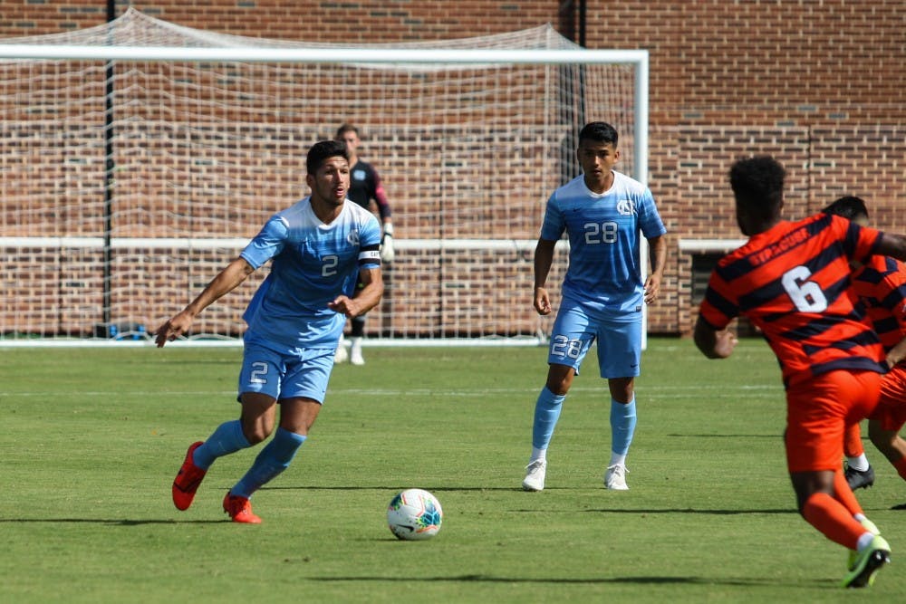 Senior midfielder and captain Mauricio Pineda (2) dribbles the ball while junior midfielder Raul Aguilera (28) watches during a game against Syracuse at Dorrance Field on Saturday, Oct. 12, 2019. The Tarheels lost 3-4.