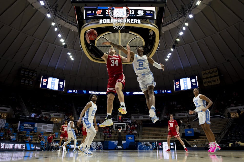 WEST LAFAYETTE, IN - MARCH 19: Brad Davison drives for a layup as Caleb Love of North Carolina defends in the first round of the 2021 NCAA Division I Men’s Basketball Tournament held at Mackey Arena on March 19, 2021 in West Lafayette, Indiana. Photo by Andy Hancock/NCAA Photos/NCAA Photos via Getty Images