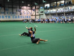 UNC majorettes Ava Smith (left) and Ciara Gillis (right) rehearse during marching band practice in the Eddie Smith field house.