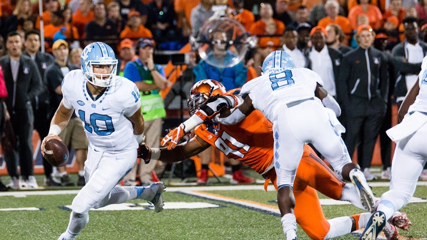North Carolina quarterback Mitch Trubisky (10) dodges a tackle from Illinois defensive lineman Dawuane Smoot (91) during the game against Illinois at Memorial Stadium on Saturday, September 10. The Tar Heels won 48-23.