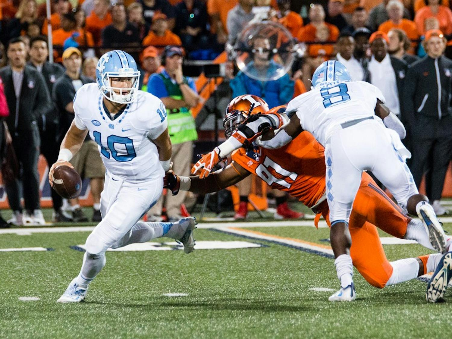North Carolina quarterback Mitch Trubisky (10) dodges a tackle from Illinois defensive lineman Dawuane Smoot (91) during the game against Illinois at Memorial Stadium on Saturday, September 10. The Tar Heels won 48-23.