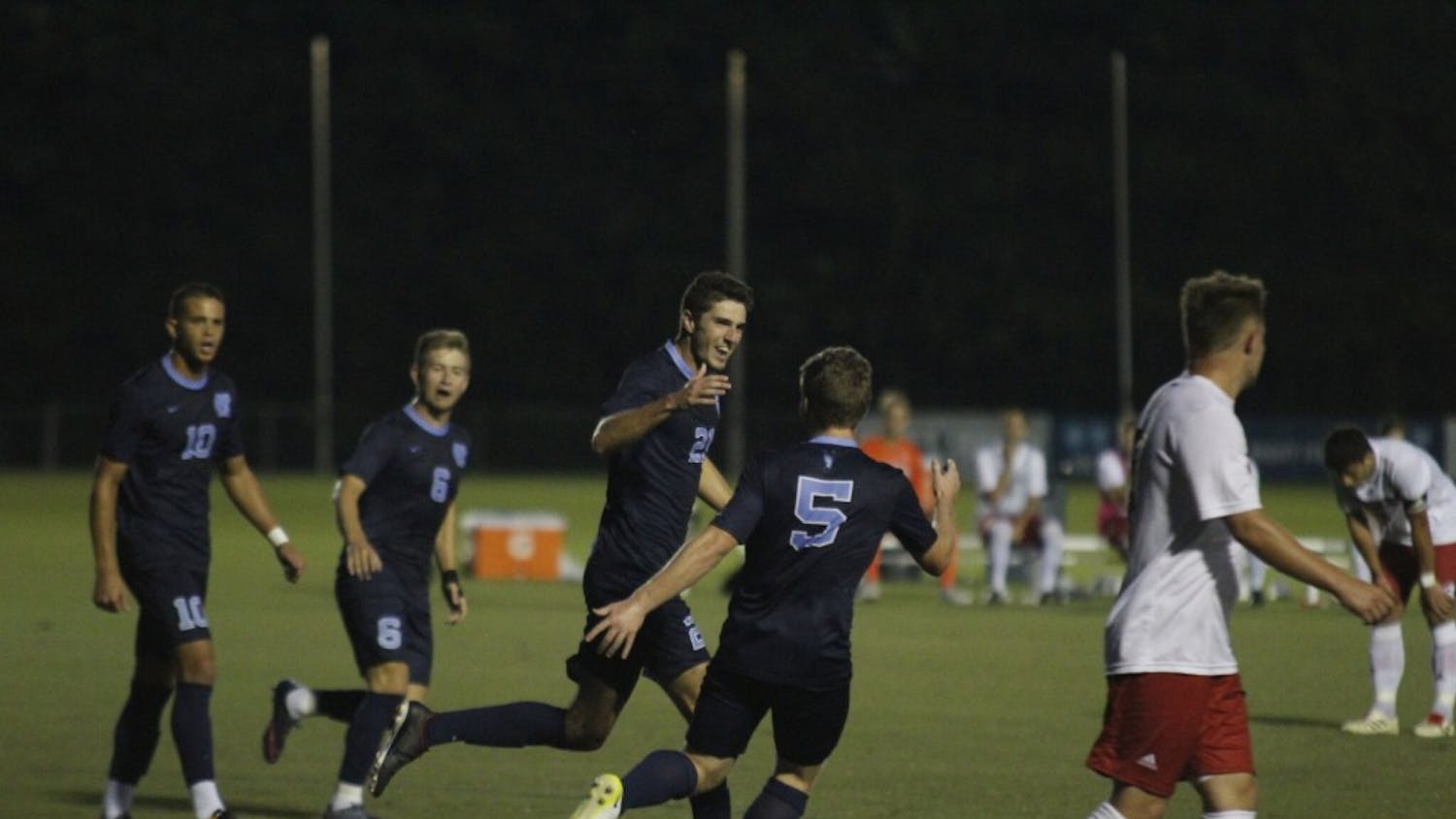 Alex Rose (21) celebrates a goal with teammate John Nelson (5). The North Carolina men's soccer team defeated Rutgers, 6-1, on Sunday night in Cary.