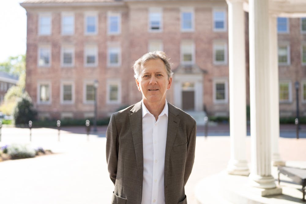 <p>Tom Kelley poses for a portrait by the Old Well, on Tuesday, April 4, 2023. Kelley is running to occupy the position of faculty chairperson for the 2023-24 academic year.&nbsp;</p>