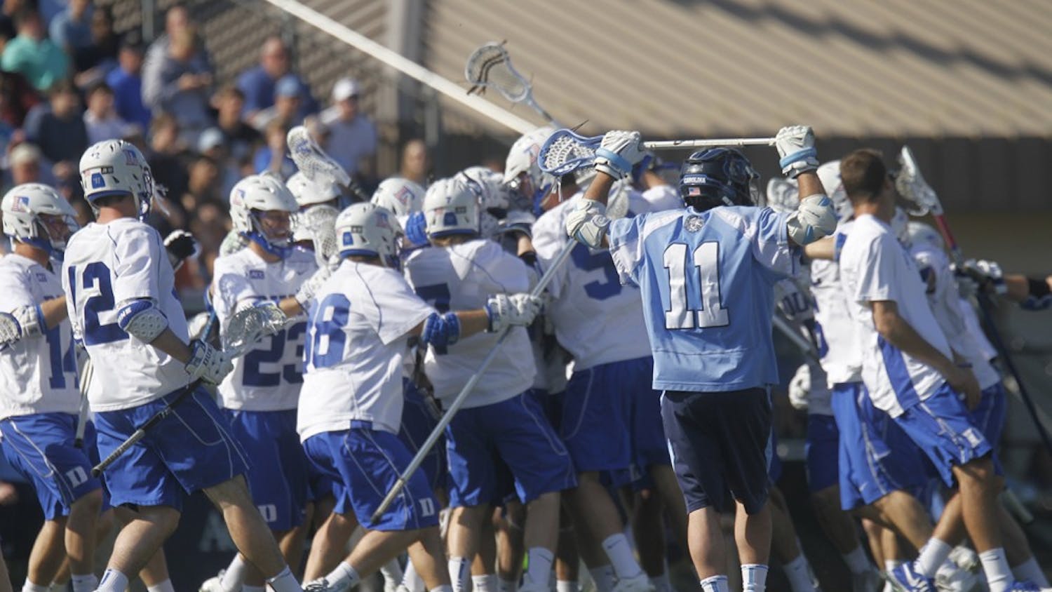 	Joey Sankey (11) puts his hands up as the Duke lacrosse team celebrates after Duke’s Jordan Wolf scored in overtime to win the game 9-8. 