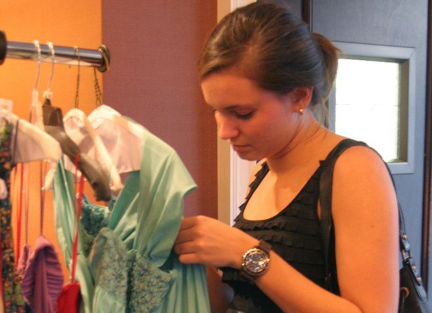 Allie Harrison, a senior psychology major from Raleigh, looks at dresses available to rent at the No Booze, No Boys Fashion Show.