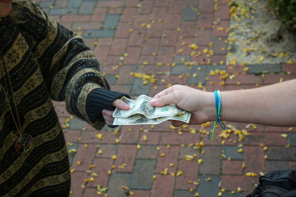 <p>DTH Photo Illustration. Two UNC students are pictured exchanging money. House Bill 347 would legalize sports betting in North Carolina.</p>
