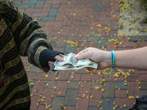 DTH Photo Illustration. Two UNC students are pictured exchanging money. House Bill 347 would legalize sports betting in North Carolina.