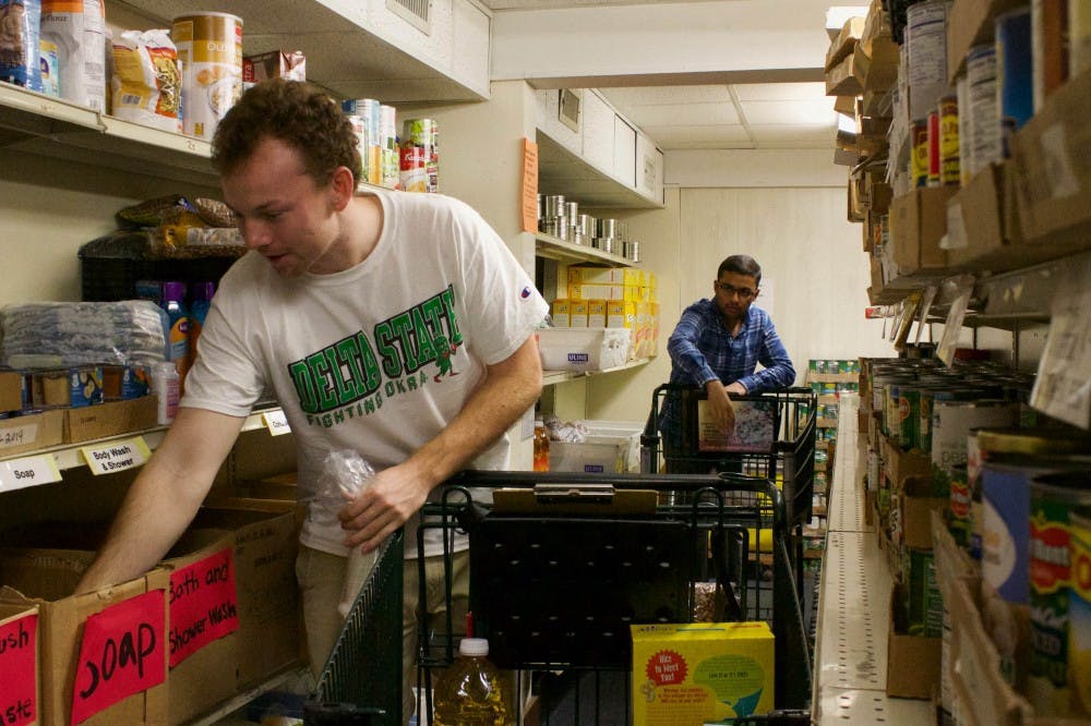 <p>(From left) Warner Lamar and Samveg Desai are both students at UNC-Chapel Hill who volunteer at the Inter-Faith Food Pantry in Carrboro. The IFC pantry also provides families with basic hygiene needs such as soap, shampoo, and toothpaste. These items are not often given out or even offered in other food pantries but IFC has thought beyond food and offered those in need with everyday essentials that everyone should have access to. Shot on Tuesday, Oct. 2, 2018.</p>