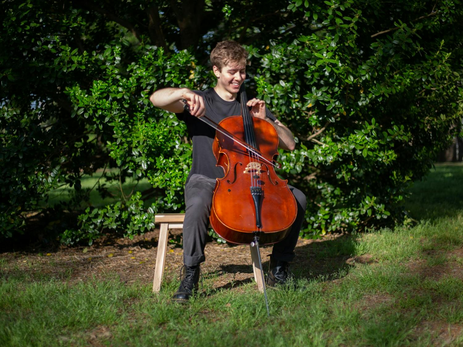 Benjamin Carter, a junior psychology major, plays his cello in McCorkle Place on Sunday, Apr. 11, 2021. Carter just released his album, Coming Out of It.