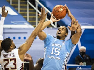 Carolina's Garrison Brooks (15) is fouled as he shoots by Florida State's Quincy Ballard (15) on Friday, March 12, 2021 in Greensboro, N.C. Photo courtesy of Andrew Dye/Winston-Salem Journal