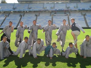 	Junior Patrick Spaugh poses with the Shaolin Monks of “Sutra” as they tour UNC, one of two spots in which “Sutra” will perform in the U.S.