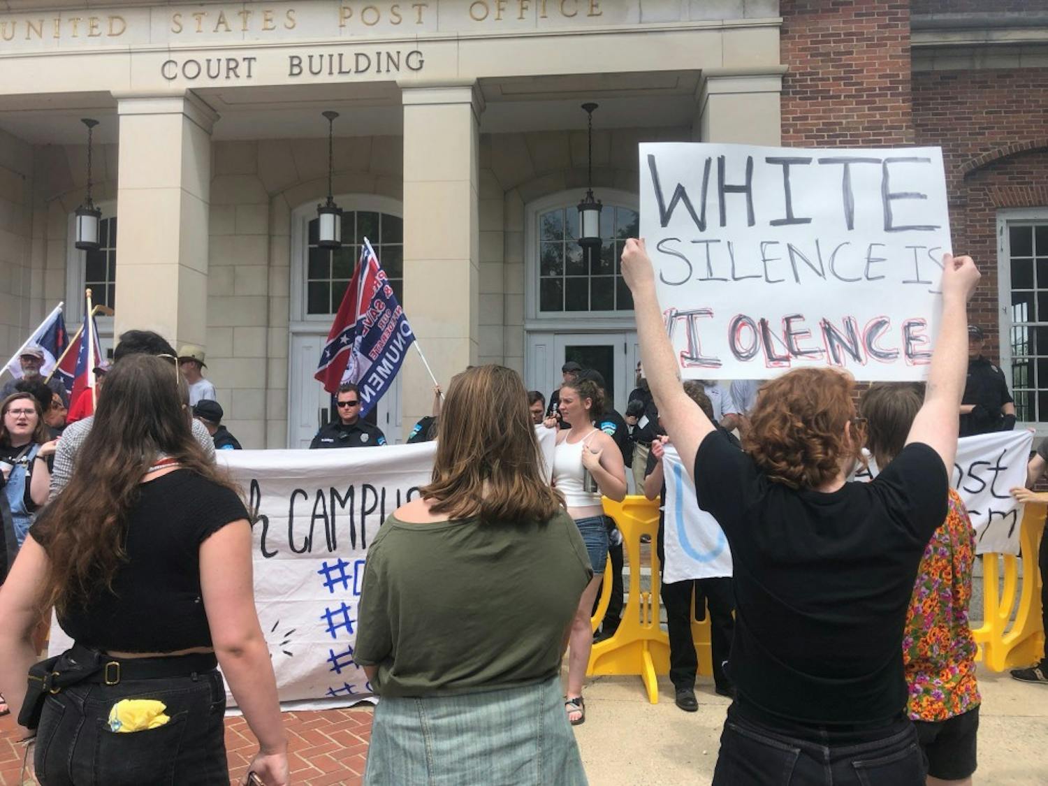 Anti-Confederate demonstrators held up signs protesting the Confederate supporters and police brutality in front of the pro-Confederates.&nbsp;