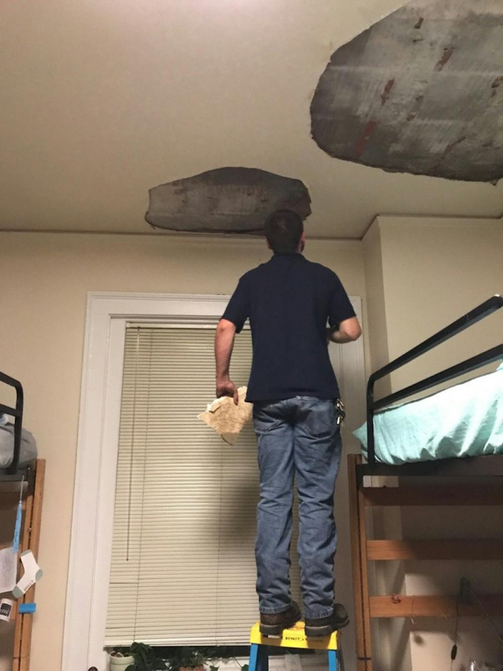 A maintenance worker inspects the ceiling in a Stacy Residence Hall room. Photo courtesy&nbsp;Anja Burcak.