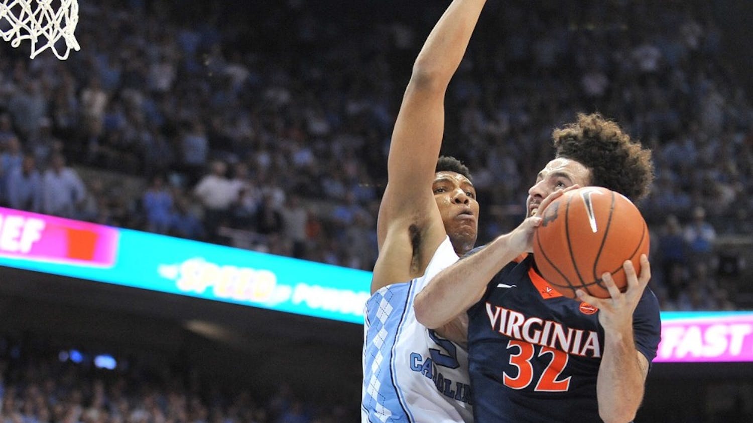 No. 10 North Carolina forward Tony Bradley (5) reaches up in an attempt to block No. 14 Virginia guard London Perrantes (32) during Saturday night’s game in the Smith Center.