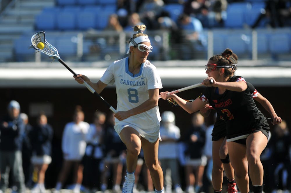 UNC senior attacker Katie Hoeg (8) keeps the ball from an opposing player during the game against Maryland at Dorrance Field on Saturday, Feb. 22, 2020. No 1. UNC won against No 4. Maryland 19-6.