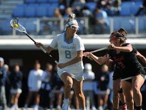 UNC senior attacker Katie Hoeg (8) keeps the ball from an opposing player during the game against Maryland at Dorrance Field on Saturday, Feb. 22, 2020. No 1. UNC won against No 4. Maryland 19-6.