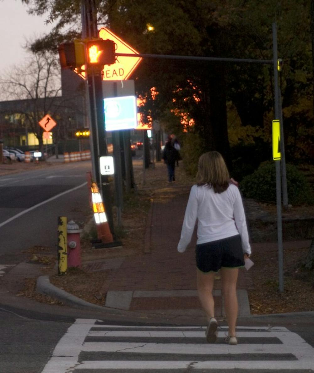 Freshman Anna van Venrooy crosses in front of a “do not walk” signal on campus.  UNC is planning to increase enforcement of jaywalking.