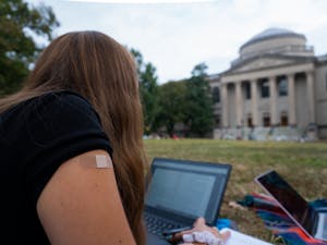 DTH Photo Illustration. A student sits on the quad after receiving a vaccine.