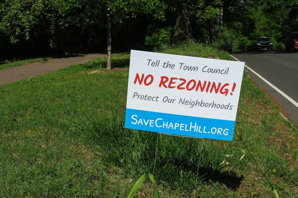 <p>A sign stands on the side of East Franklin Street in Chapel Hill on April 16. It is meant to encourage people to fight against rezoning policies.</p>