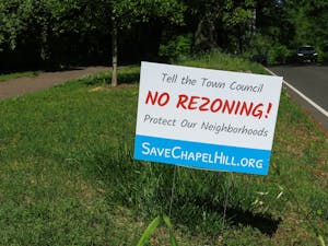 A sign stands on the side of East Franklin Street in Chapel Hill on April 16. It is meant to encourage people to fight against rezoning policies.
