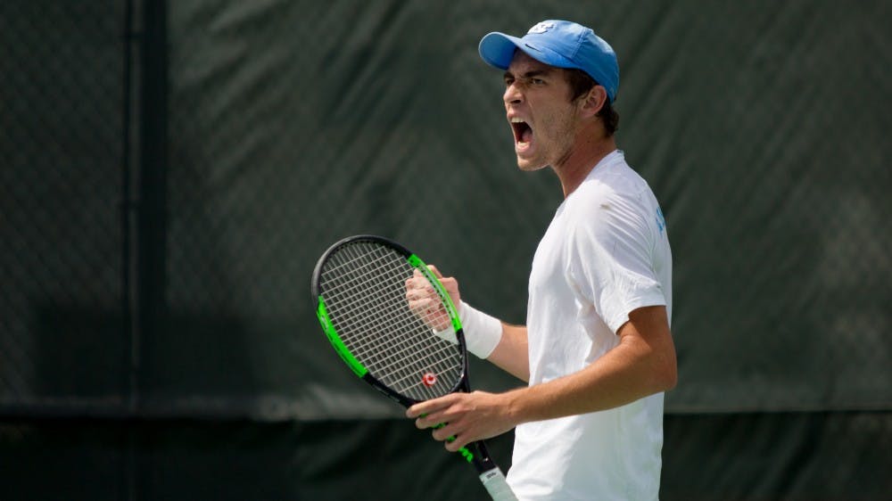 <p>First-year Ben Sigouin celebrates during a match against Virginia on April 1 at the Cone-Kenfield Tennis Center.</p>