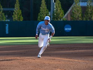UNC junior catcher Tomas Frick (52) wastes no time getting to third base in the April 11, 2023 baseball game against Queens University of Charlotte in Boshamer Stadium.