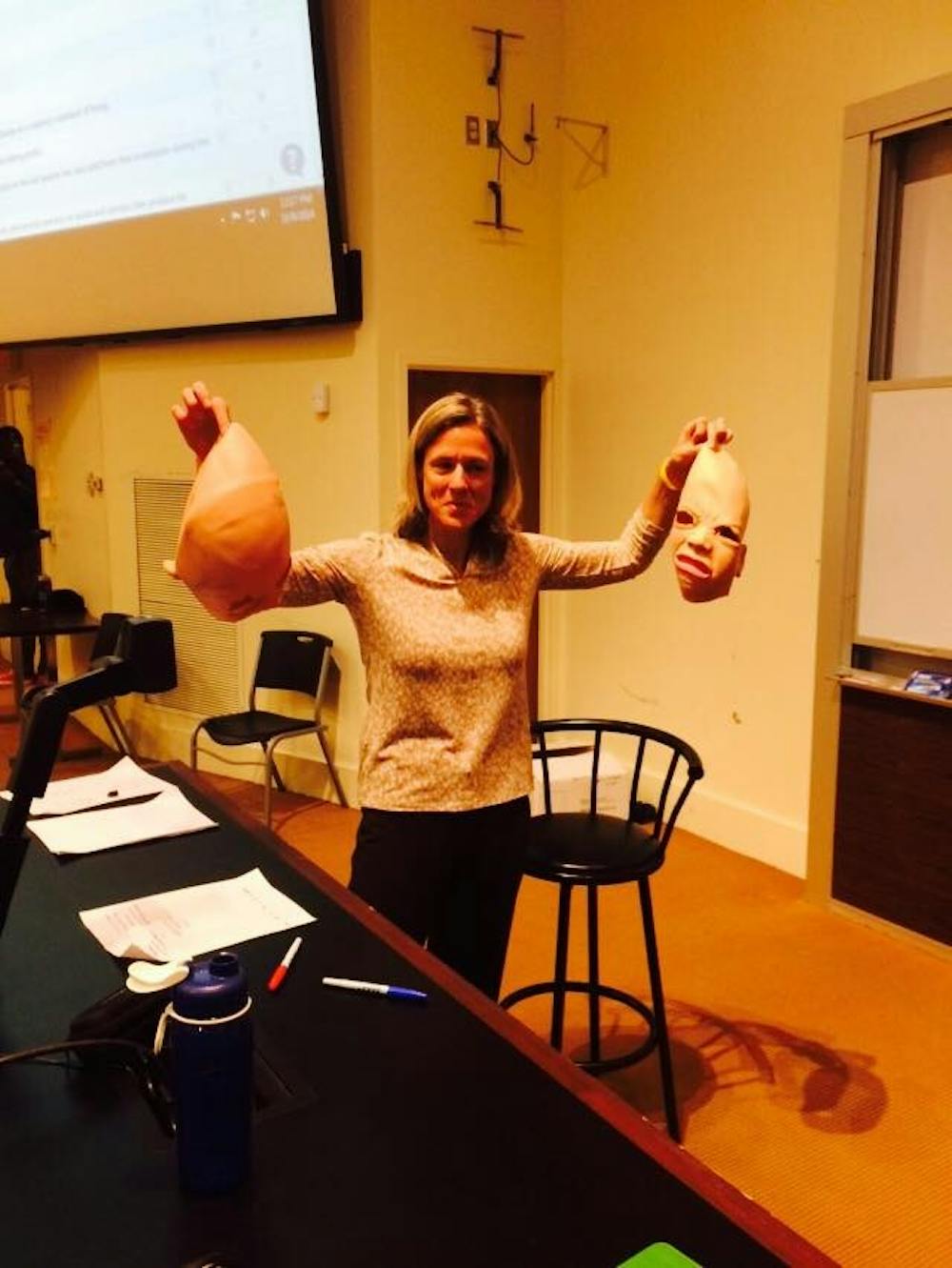 <p>Professor Rita Balaban stands with the two masks she removed from streakers who interrupted her class on Thursday.</p>