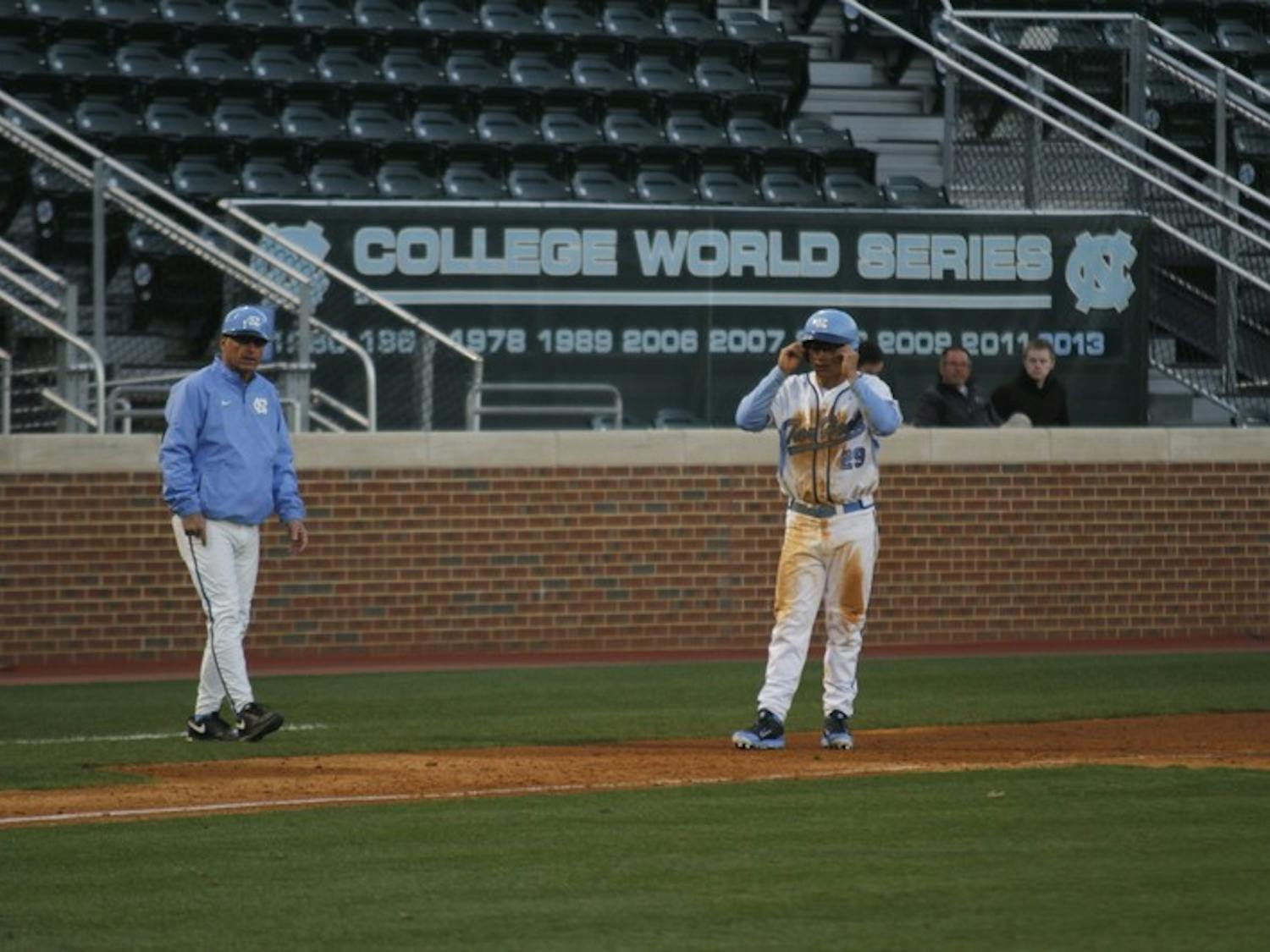 North Carolina head coach Mike Fox talks to outfielder Tyler Ramirez at third base in Tuesday's win over Appalachian State.