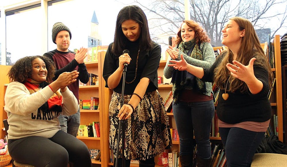 UNC Wordsmiths Mariah Monsanto, Wil Broadwell, Lauren Bullock, Polina Bastrakova, and Julia McKeown, pictured on Thursday in Bulls Head Bookshop, are getting ready for a Grand Slam on Saturday night. Bullock approaches the mic as her teammates support her.