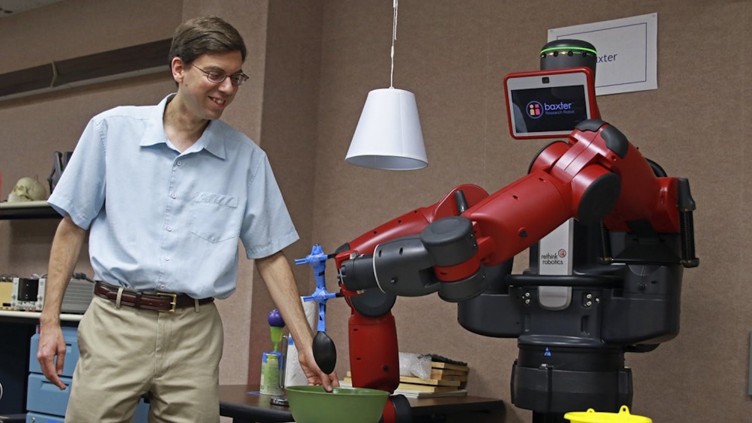 Professor Ron Alterovitz demonstrates the functions of one of the robots he and his students programmed.